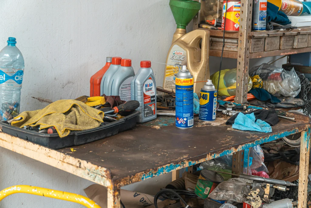 Garden tools being sharpened and oiled on a workbench during rainy weather
