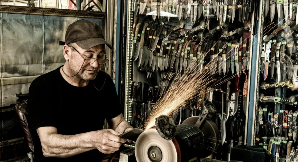 Garden tools being sharpened and oiled on a workbench during rainy weather 