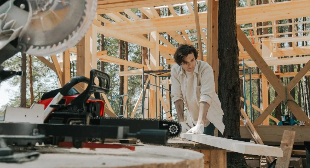 Person building a simple 4x4 raised bed frame from lumber in a backyard